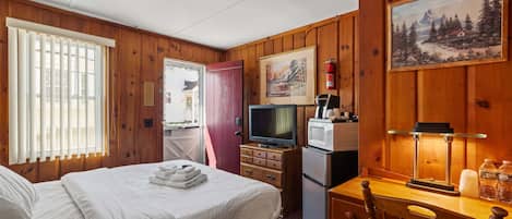 Welcome to your cozy Queen Room Retreat, featuring vintage pine paneling, a comfy bed with premium linens, and modern comforts for a relaxing stay.