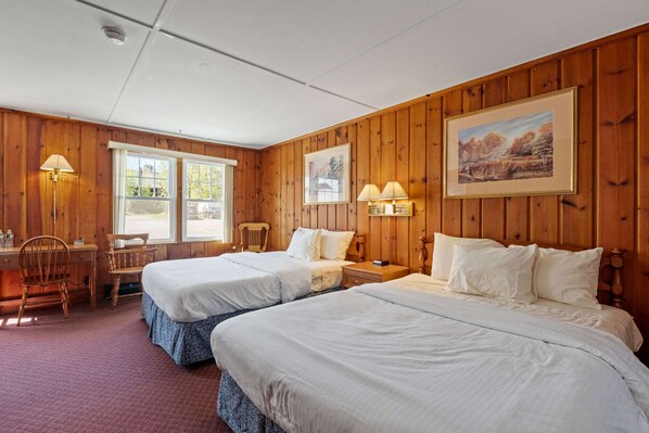 Welcome to your cozy Double Queen Room Retreat, featuring vintage pine paneling, a comfy bed with premium linens, and modern comforts for a relaxing stay.