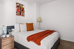 The second bedroom with a queen sized bed & plush pillows.