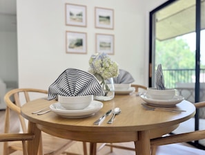 Dining for 4 with modern dishware, silverware and natural lighting.