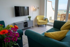 Sitting room with wall mounted TV above storage cupboard