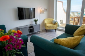 Sitting room with wall mounted TV above storage cupboard