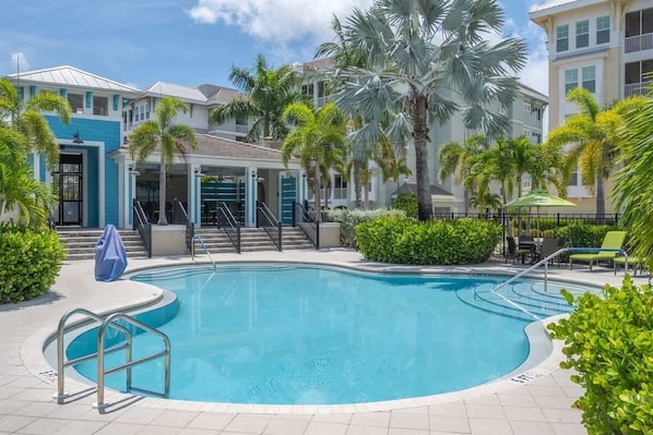 Resort-style pool surrounded by lush palms.