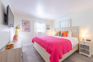 Bedroom with a king bed, colorful pillows, and wall-mounted TV. Includes ample closet space and private bath.