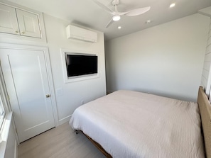 One of two king bedrooms with built-in storage and wall-mounted TV.