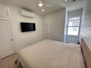 Inviting king bedroom with stylish decor, plush bedding, and wardrobe storage.