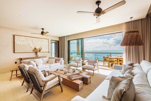 Sala de estar con vista al mar y acceso a la terraza privada, cuenta con ventiladores en techo, aire acondicionado 