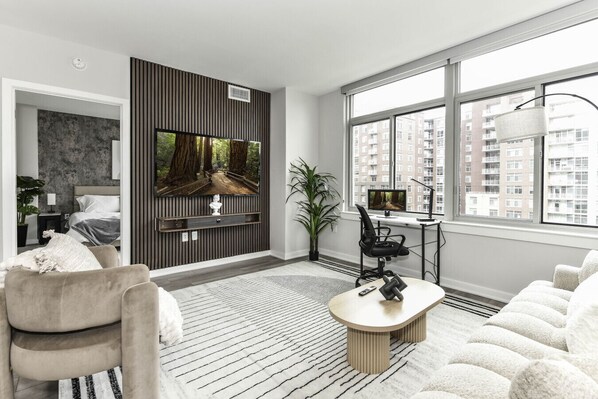 Chic and bright living room with cozy couch, flatscreen Tv and dedicated work station