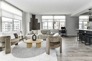 Chic and bright living room with cozy couch, flatscreen Tv and dedicated work station