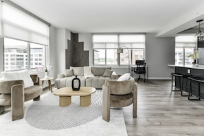Chic and bright living room with cozy couch, flatscreen Tv and dedicated work station
