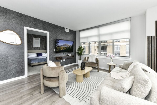 Chic and bright living room with cozy couch, flatscreen Tv and dedicated work station