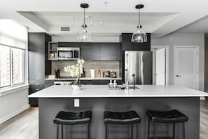 Fully equipped kitchen with a breakfast counter (seats 3) and a dining area (seats 4), plus a high chair available for little ones.