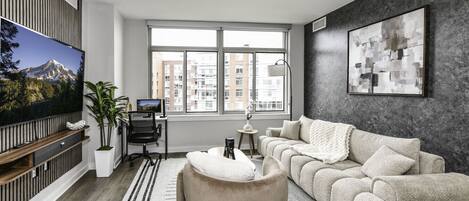 Chic and bright living room with cozy couch, flatscreen Tv and dedicated work station