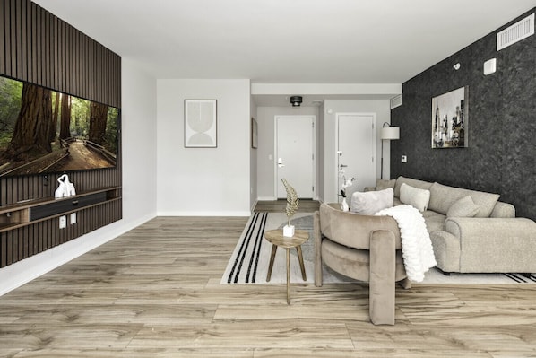 Chic and bright living room with cozy couch, flatscreen Tv and dedicated work station