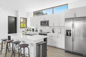The large kitchen features a breakfast bar and stainless steel appliances.  