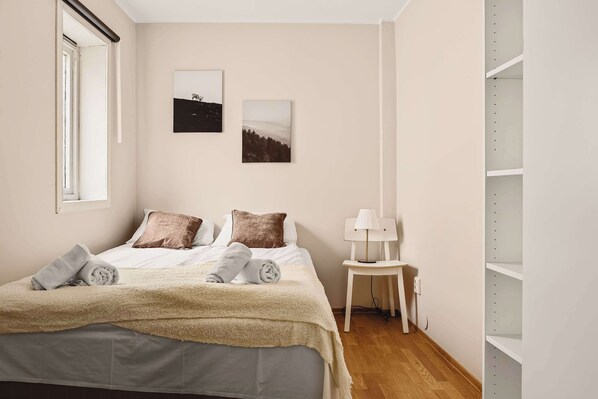 A peaceful bedroom featuring soft beige walls, minimal decor, and plush pillows for a restful night’s sleep.