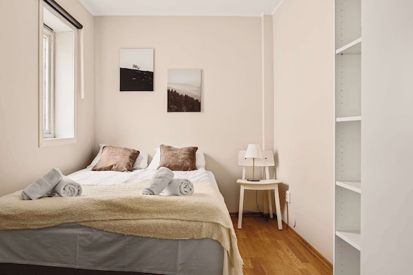 A peaceful bedroom featuring soft beige walls, minimal decor, and plush pillows for a restful night’s sleep.