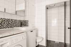 A fresh and modern bathroom, complete with a glass shower, sleek fixtures, and a mosaic tile detail for a sophisticated touch.