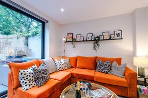 Our elegant and inviting living space features a vibrant custom sectional, sleek Smart TV, and seamless indoor-outdoor flow to a private garden terrace - ideal for sophisticated relaxation or entertaining. It even includes a sofa bed.