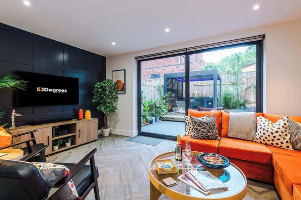 Our elegant and inviting living space features a vibrant custom sectional, sleek Smart TV, and seamless indoor-outdoor flow to a private garden terrace - ideal for sophisticated relaxation or entertaining. It even includes a sofa bed.