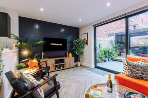 Our elegant and inviting living space features a vibrant custom sectional, sleek Smart TV, and seamless indoor-outdoor flow to a private garden terrace - ideal for sophisticated relaxation or entertaining. It even includes a sofa bed.