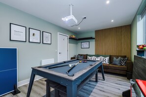 Our games room offers the ultimate in entertainment and comfort featuring a convertible pool table that transforms into a dining or table tennis setup, a cinema-style projector with full Virgin Media package, and a mini fridge stocked up!