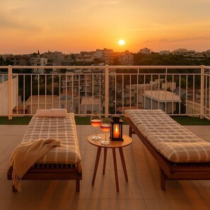 Bright, open rooftop with loungers and sweeping city views.
