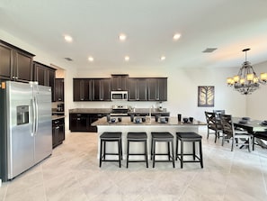 Sleek dark cabinets, and a large island with seating for at least 5.