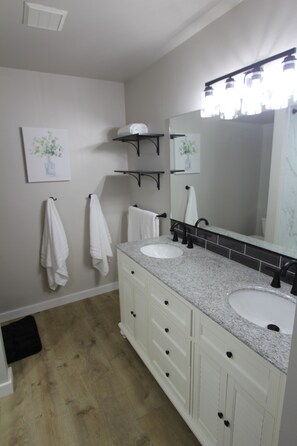 Bright bathroom with fresh, soft towels, double vanity, and full mirror.