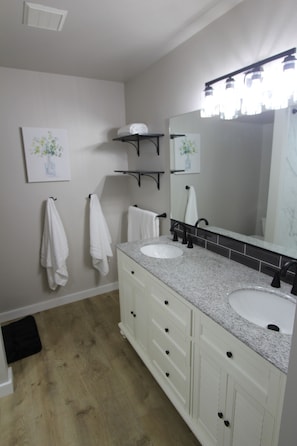 Bright bathroom with fresh, soft towels, double vanity, and full mirror.