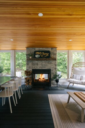 Three-season porch with indoor-outdoor fireplace—where comfort meets the outdoors.