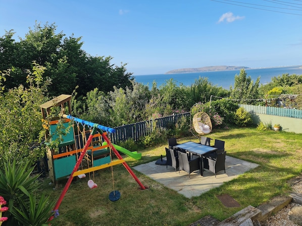 Garden with sea view. Comfy Garden chairs and egg chair. For kids swing and slide ofcourse 😉