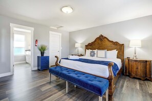 Elegant and spacious primary bedroom with a king-size bed, classic wood accents, and large windows that showcase stunning mountain views