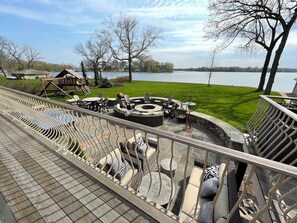 Lake-side view of patio. Firepit, Playset, seating areas. 