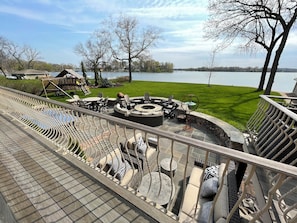 Lake-side view of patio. Firepit, Playset, seating areas.