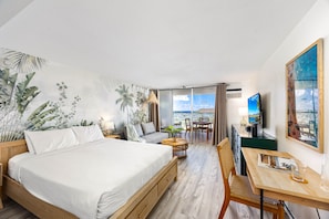 Beautiful studio with queen-size bed perfect for relaxing, designated working space with table and chair, futon sofa, window AC, and a 54" Smart TV.