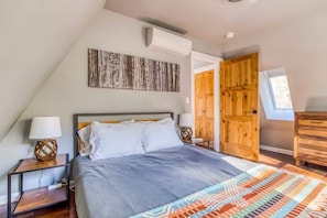 Relax in this bright, cozy bedroom with unique artwork and a comfy bed. Your perfect rest stop!