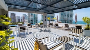 Shaded dining tables poolside with the spectacular view