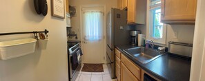 Kitchen with fridge, dishwasher, microwave, exhaust fan and convection range.
