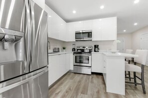 Fully stocked kitchen with complete set of cookware.
