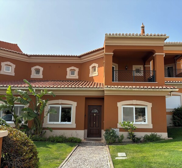 Front of linked villa with pretty garden 