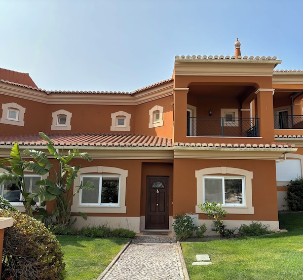 Front of linked villa with pretty garden