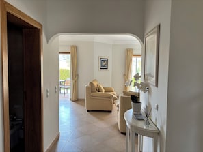 Light and open hallway leading to living area with golf course views