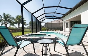 Pool in backyard with hot tub