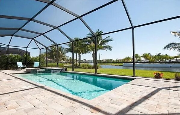 Pool in backyard with hot tub