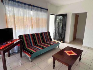 Sala (sillón de 4 plazas, centro de mesa, pequeño mueble con tv, entrada de la casa, cortinero)