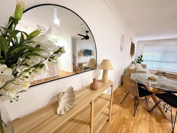Cozy dining corner with a round table and four chairs, complemented by a decorative mirror beside the table, adding a stylish touch and visual interest to the space.
