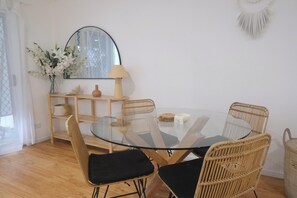 Round glass dining table with wicker chairs.