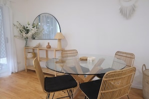 Round glass dining table with wicker chairs.
