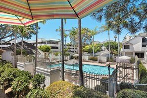 Step onto the balcony for a peaceful view of the pool, ideal for morning coffee or sunset lounging.